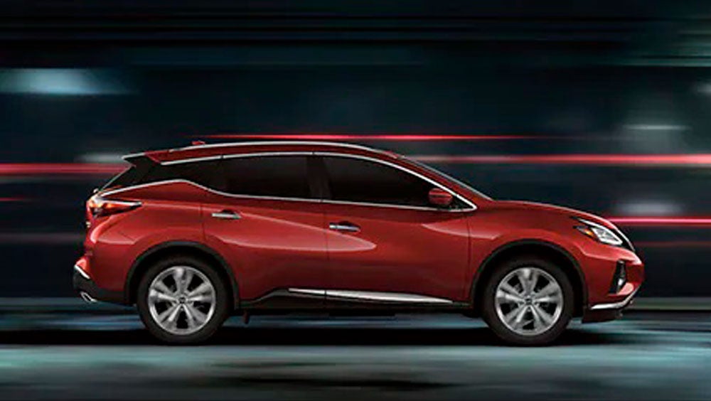 2023 Nissan Murano shown in profile driving down a street at night illustrating performance. | Greeley Nissan in Greeley CO